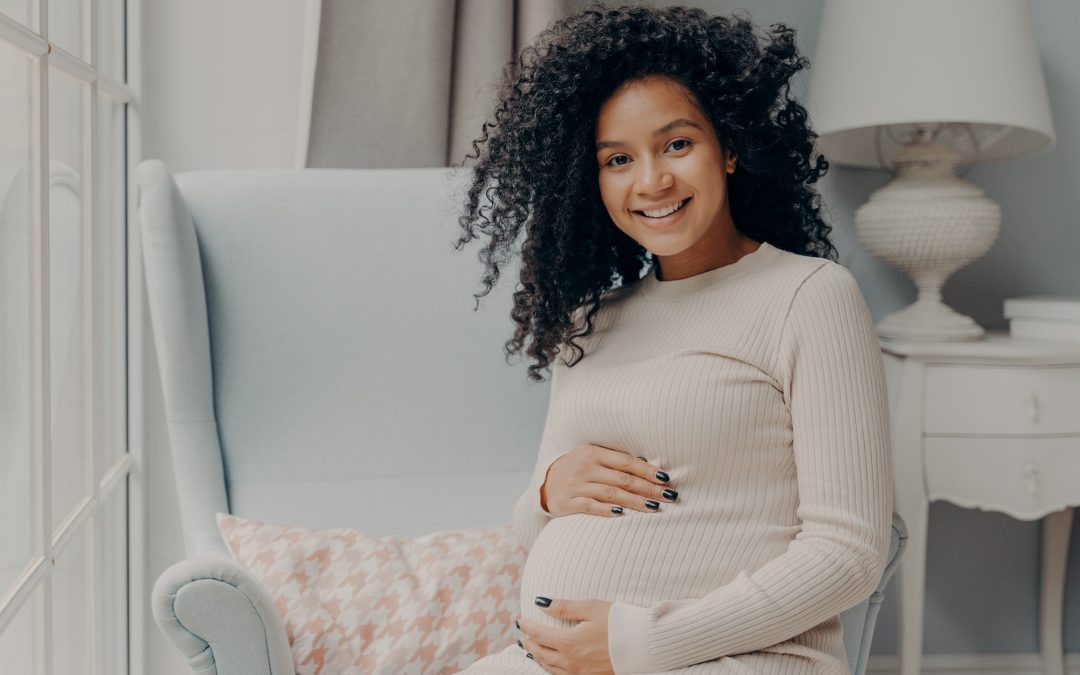 Beautiful pregnant african woman enjoying pregnancy, spending time at home