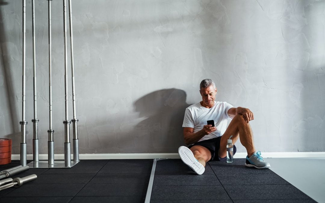 Mature man checking his messages after a health club workout