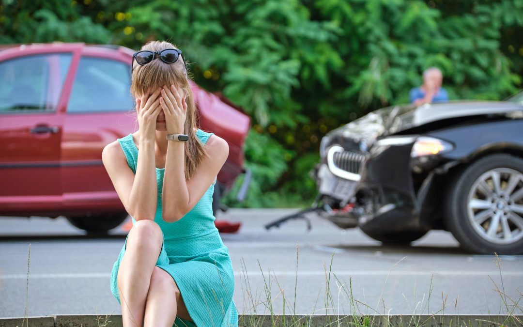 Stressed woman driver sitting on street side shocked after car accident. Road safety and insurance