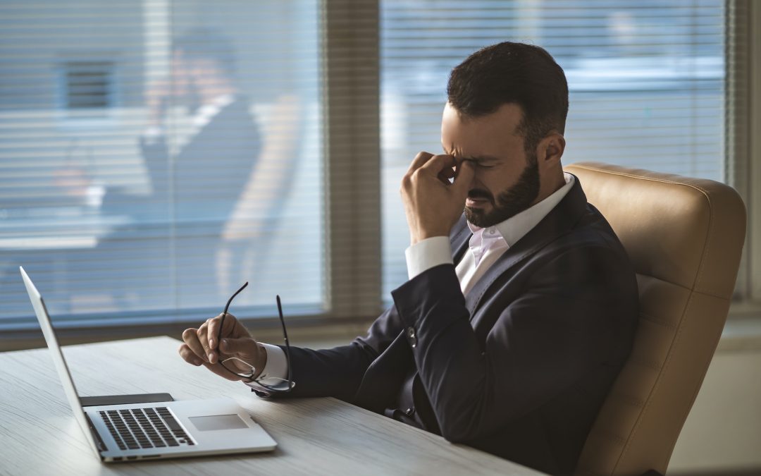 The businessman with headache sitting at the table