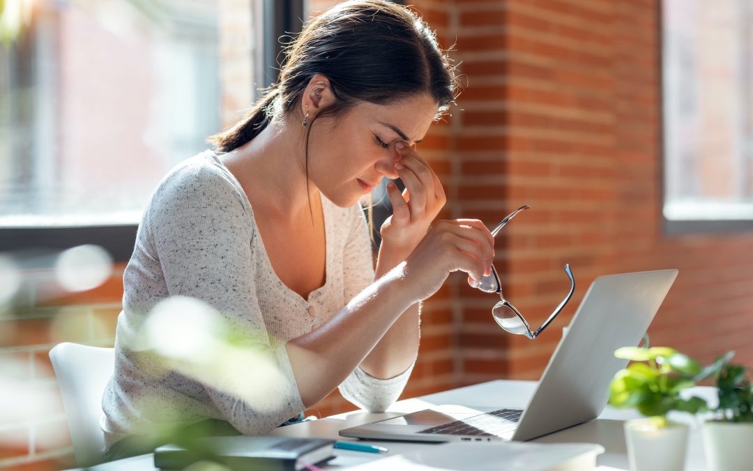 Tired business woman with headache looking uncomfortable while working with computer in the office