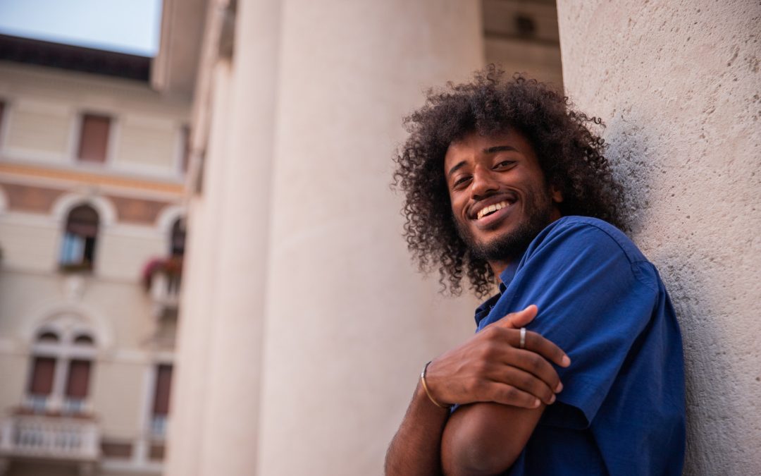 Portrait of a smiling young african boy with afro, photo from below, happy person.