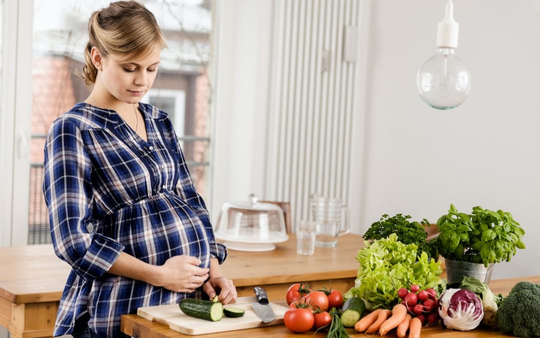 Pregnant woman chopping vegetables