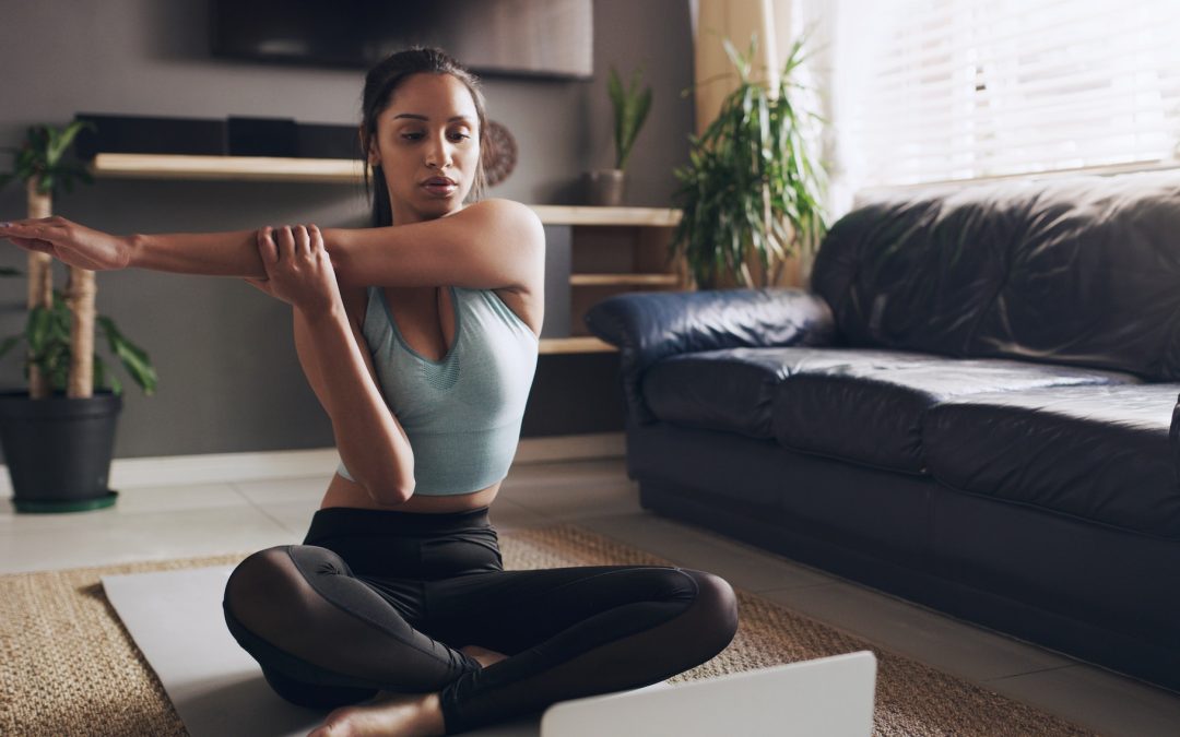 Stretch to prevent injuries. Shot of a young woman stretching before a workout at home.