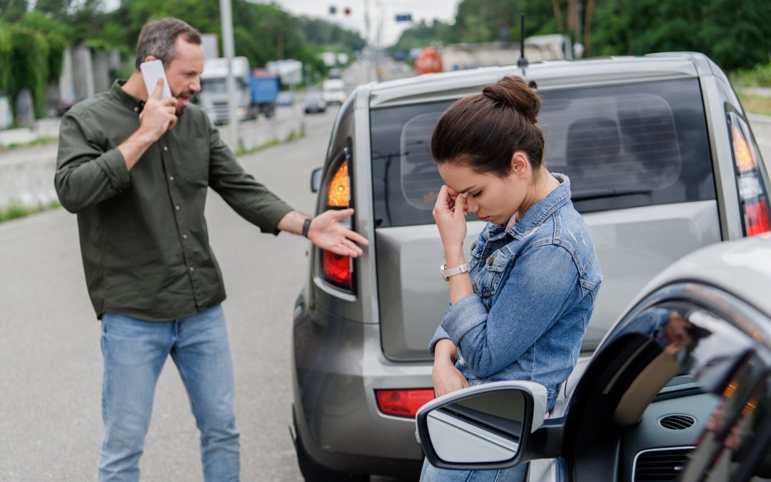 upset man and woman near cars after car accident