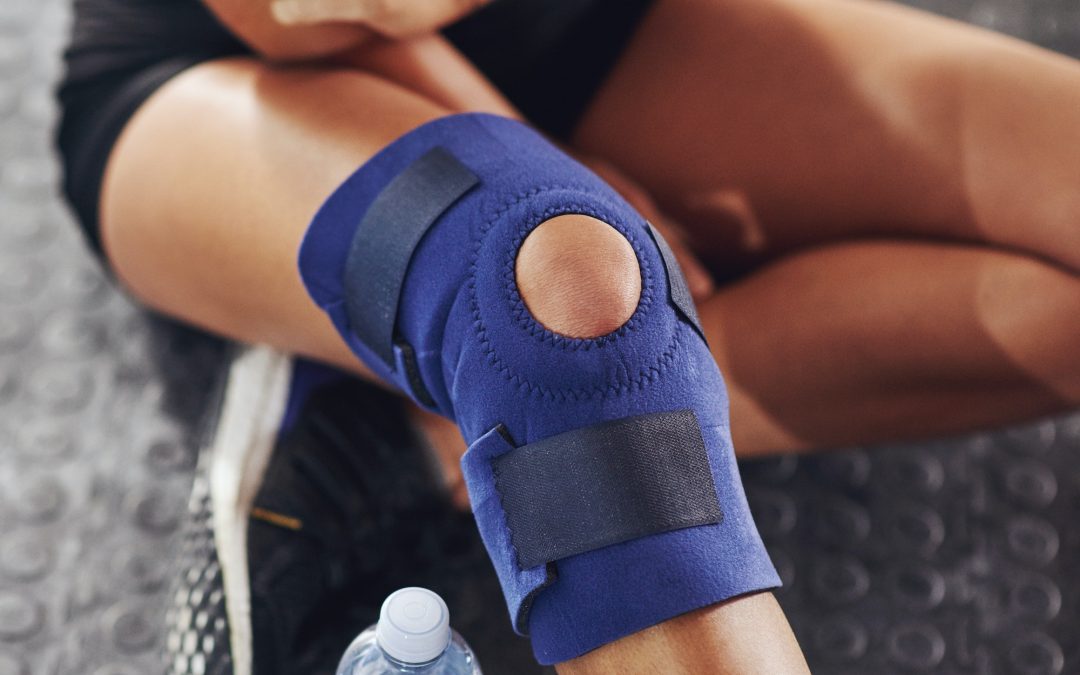 Dealing with injury. Shot of a sportswoman wearing a knee brace.